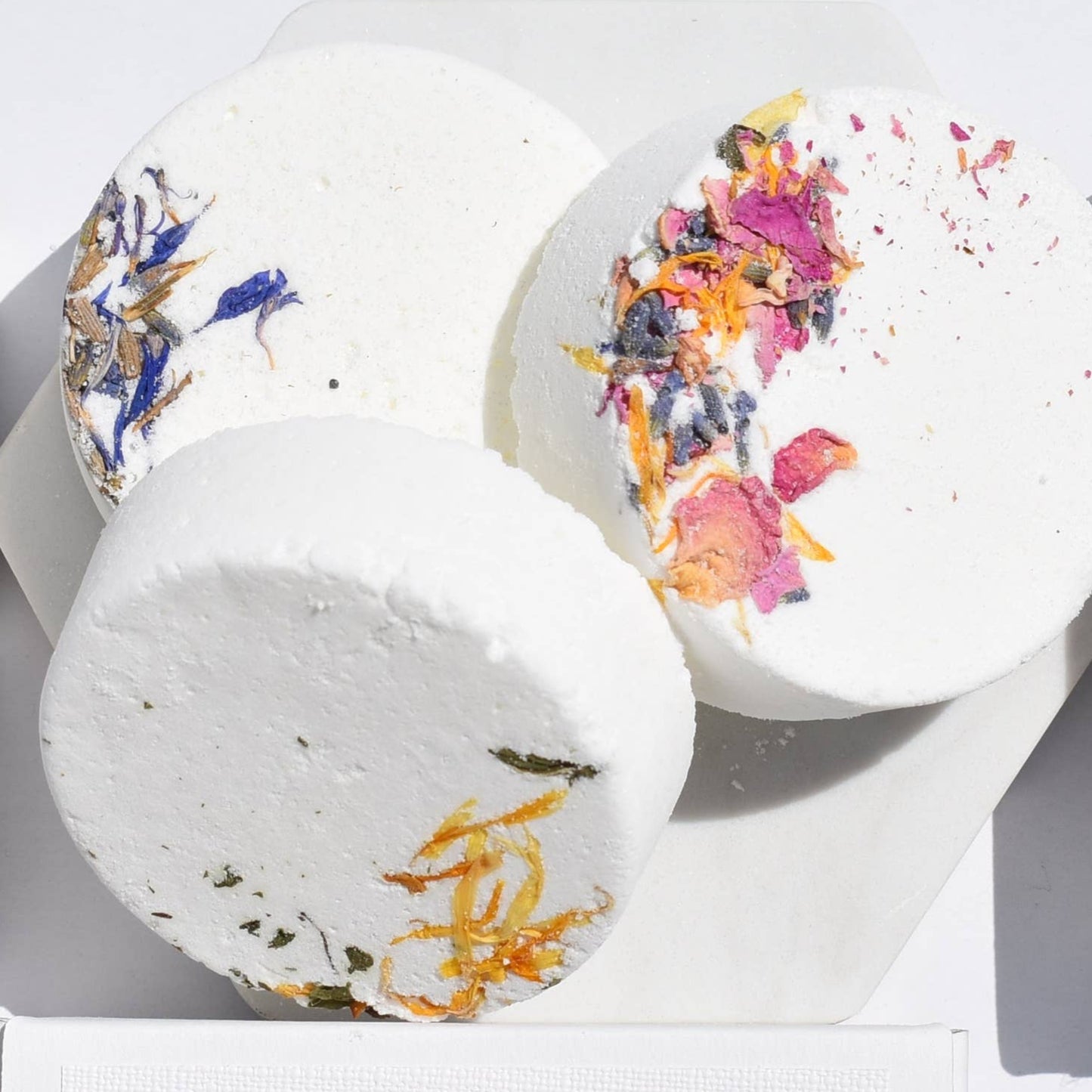 Three single bath fizzers with floral designs on the packaging, labeled 'The Path to Beauty - Inner Peace', 'The Path to Beauty - Breathe', and 'The Path to Beauty - Tranquil'. They are presented on a white background with a decorative border.