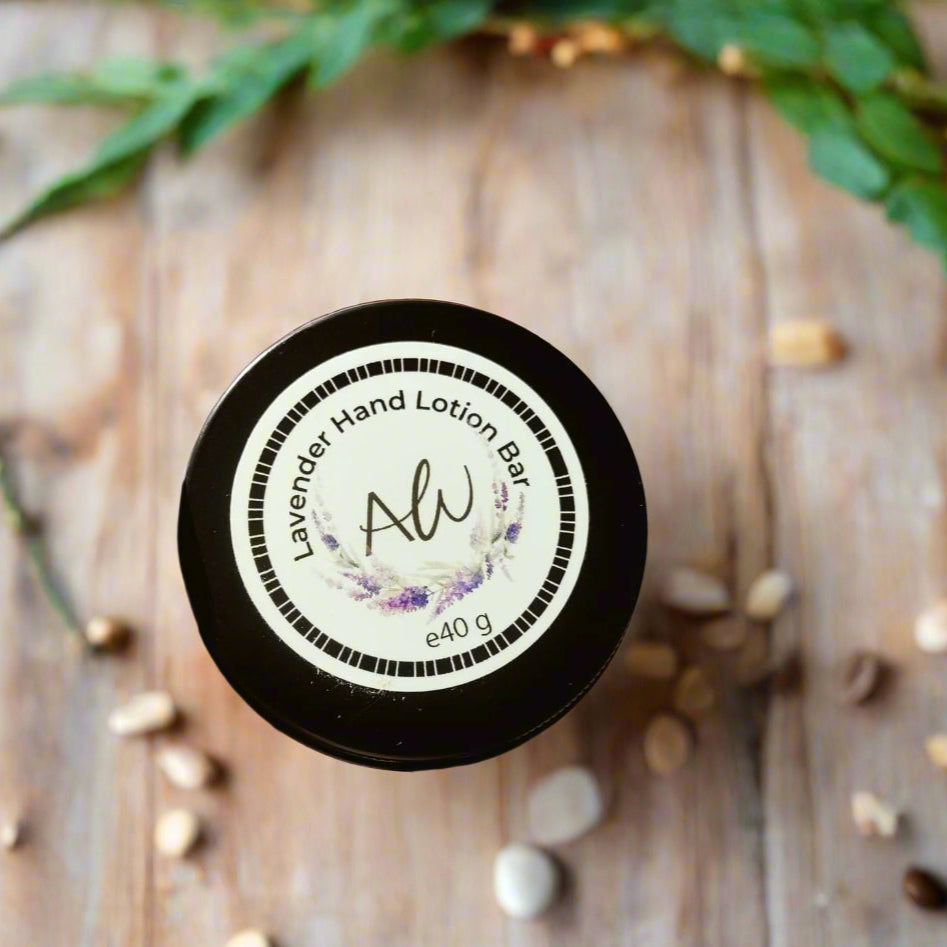 A hand holding a black lotion bar labeled 'Alaraway Hand Lotion Bar' with a weight of 40 gm, against a brick wall background.