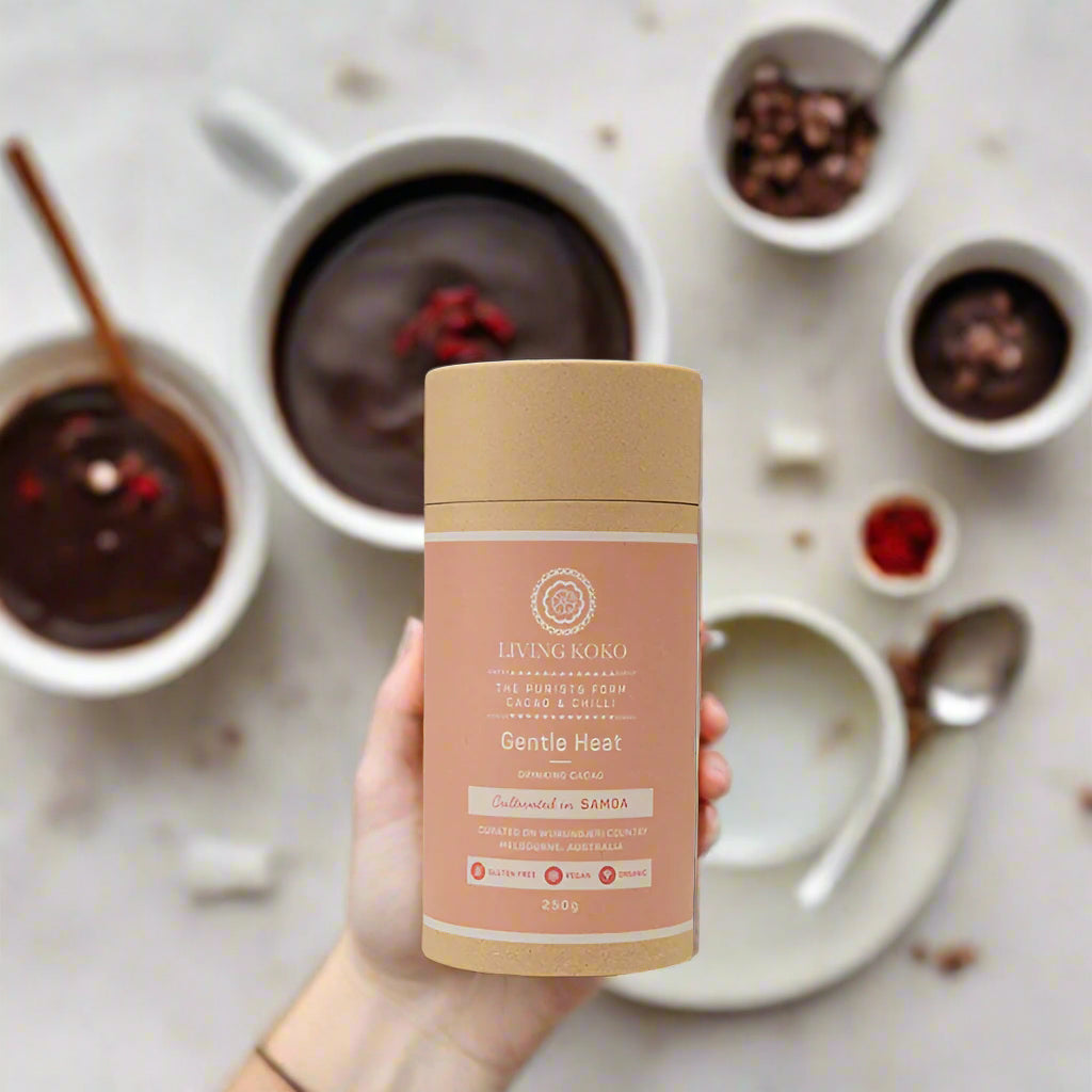 A cylindrical tube packaging of Living Koko Gentle Heat Drinking Cacao with Chilli, 250g, with a beige and pink label.