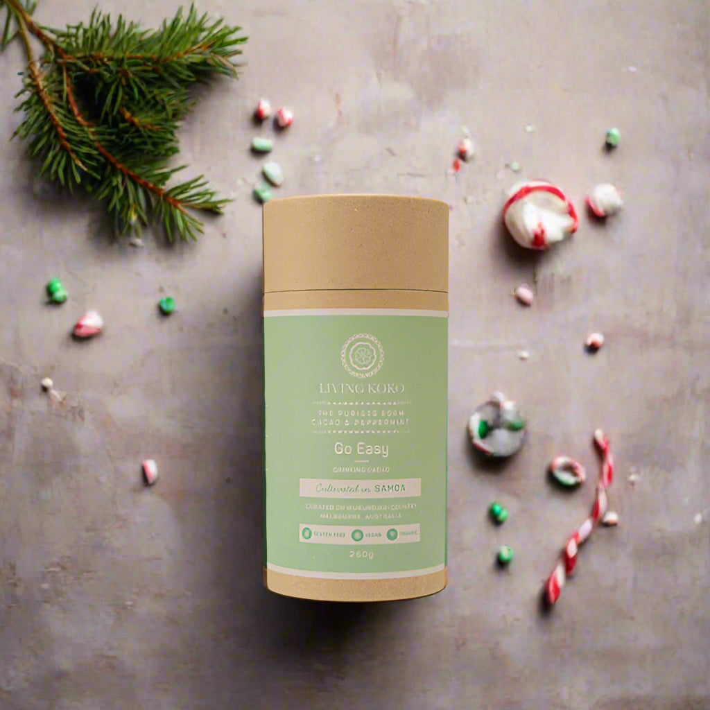 A cylindrical cardboard packaging with a green label, text, and the brand Living Koko's logo, for a product named 'Go Easy' which is a drinking cacao.
