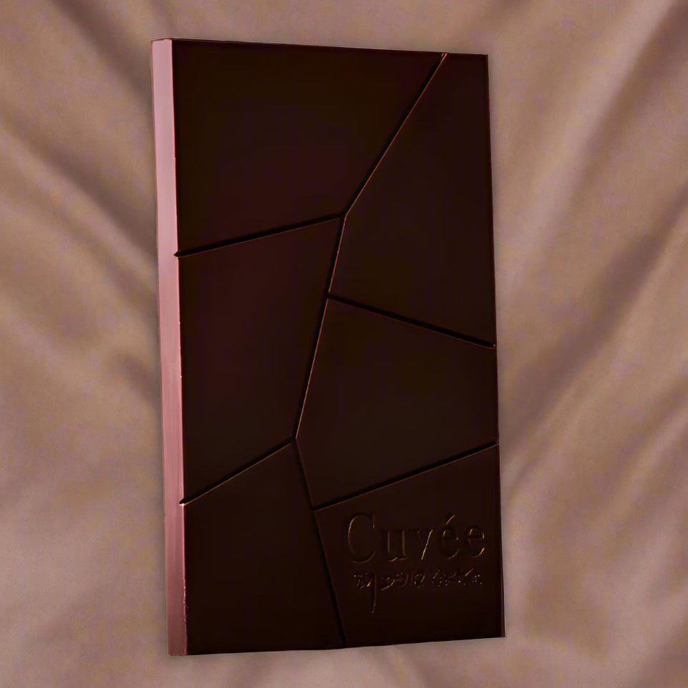 Dark chocolate bar with 'Cuvee' branding on a textured brown background