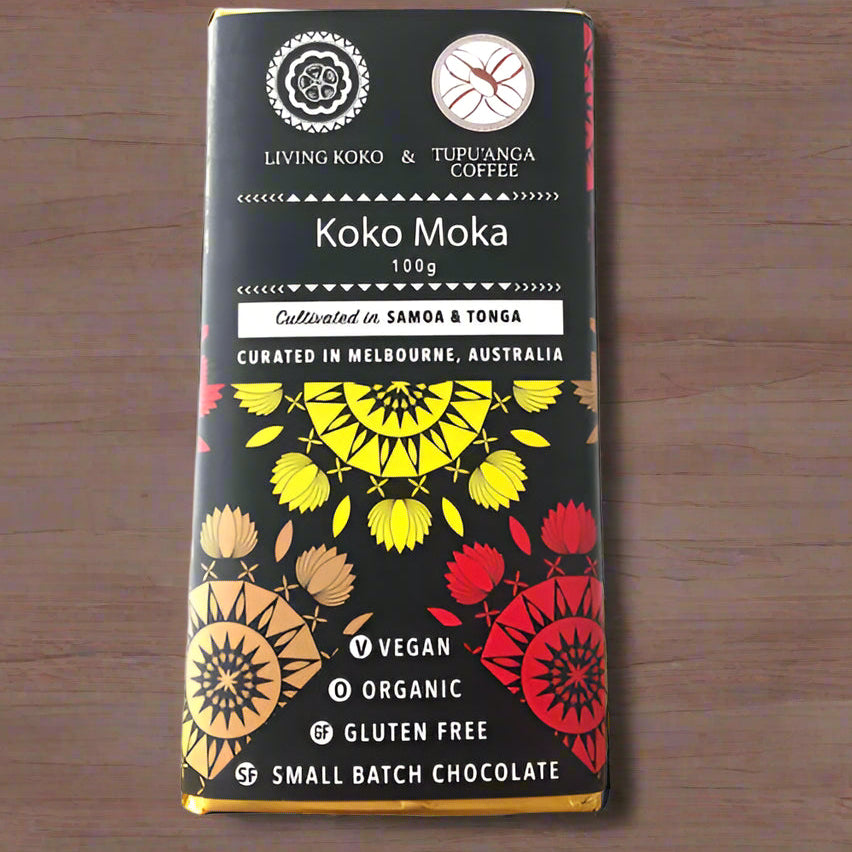 A chocolate bar packaging with a colorful design featuring geometric shapes in red, black, and yellow. The text indicates the product is 'Koko Moka', 100g, made with organic dark chocolate and tupu'anga coffee, vegan, organic, and gluten-free.