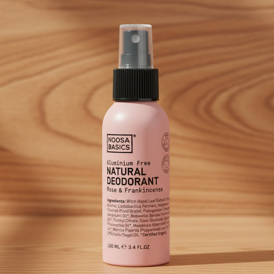 A pink spray bottle labeled 'Noosa Basics Natural Deodorant Rose & Frankincense' which is alumium free