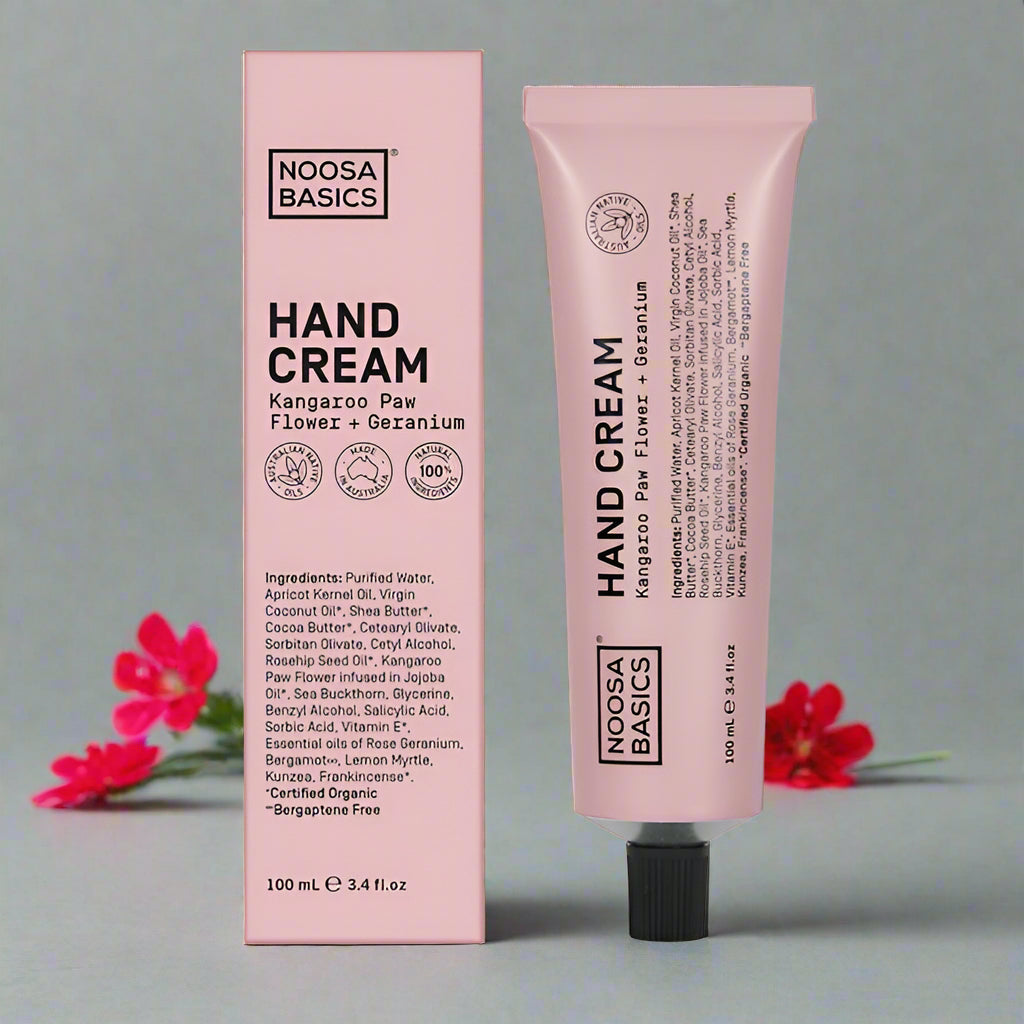 The image shows a hand cream tube and packaging with the brand Noosa Basics. The product is titled Kangaroo Paw Flower + Geranium.