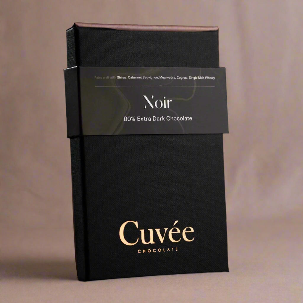 Black chocolate packaging with 'Cuveé' branding on a black background