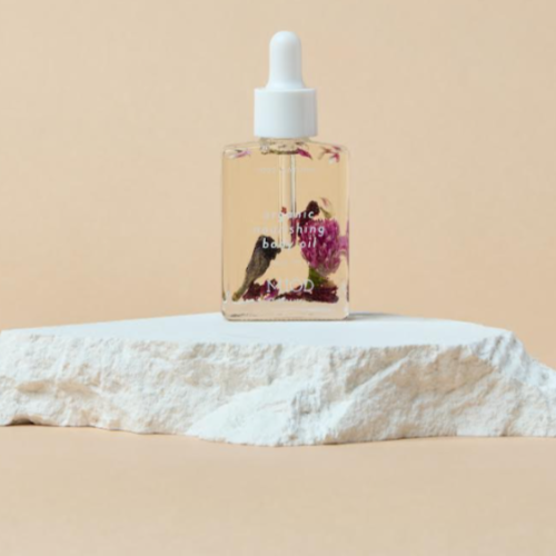 this is an image of a body oil in a glass bottle