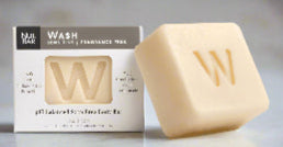A solid body wash bar next to its packaging, which indicates it is pH balanced, soap-free, and suitable for sensitive skin.