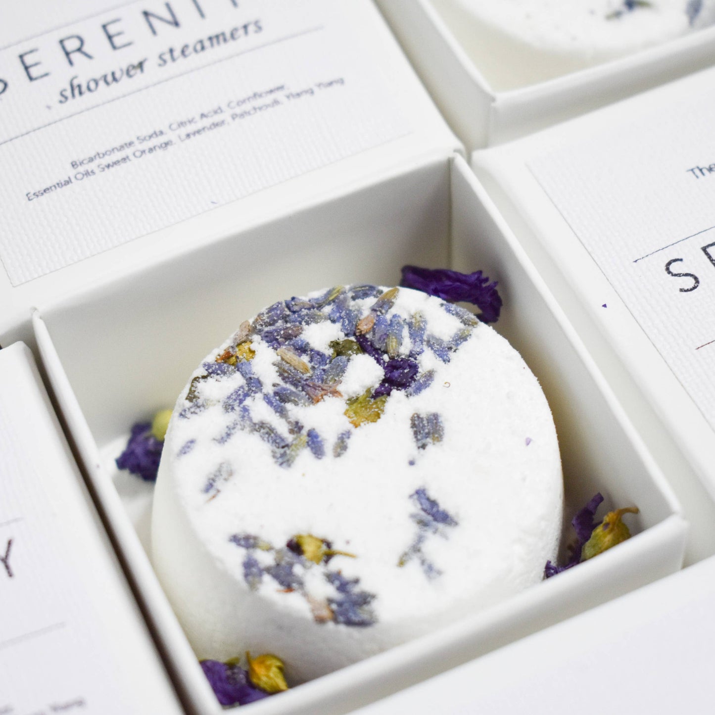 Serenity shower steamers with lavender and rose petals in a box.