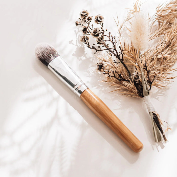 image of a bamboo brush used to apply make up and face scrubs and a posy