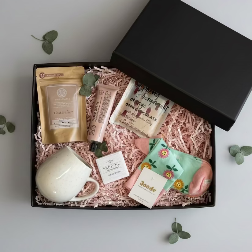Collection of beauty products including a mug, soap, and skincare items on a white surface.