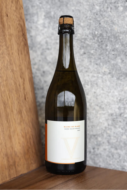 Wine bottle with a cork on a wooden surface and gray textured background