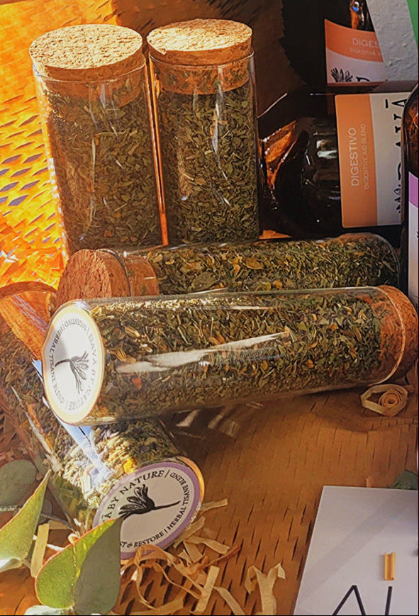 Three glass jars with cork lids containing dried herbs on a wooden surface.