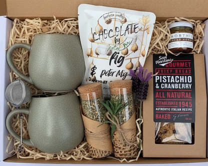 Gift box with two ceramic mugs, a tea infuser ,2 x dava test tube loose tea ,short hive honey ,large chocolate and biscuits.