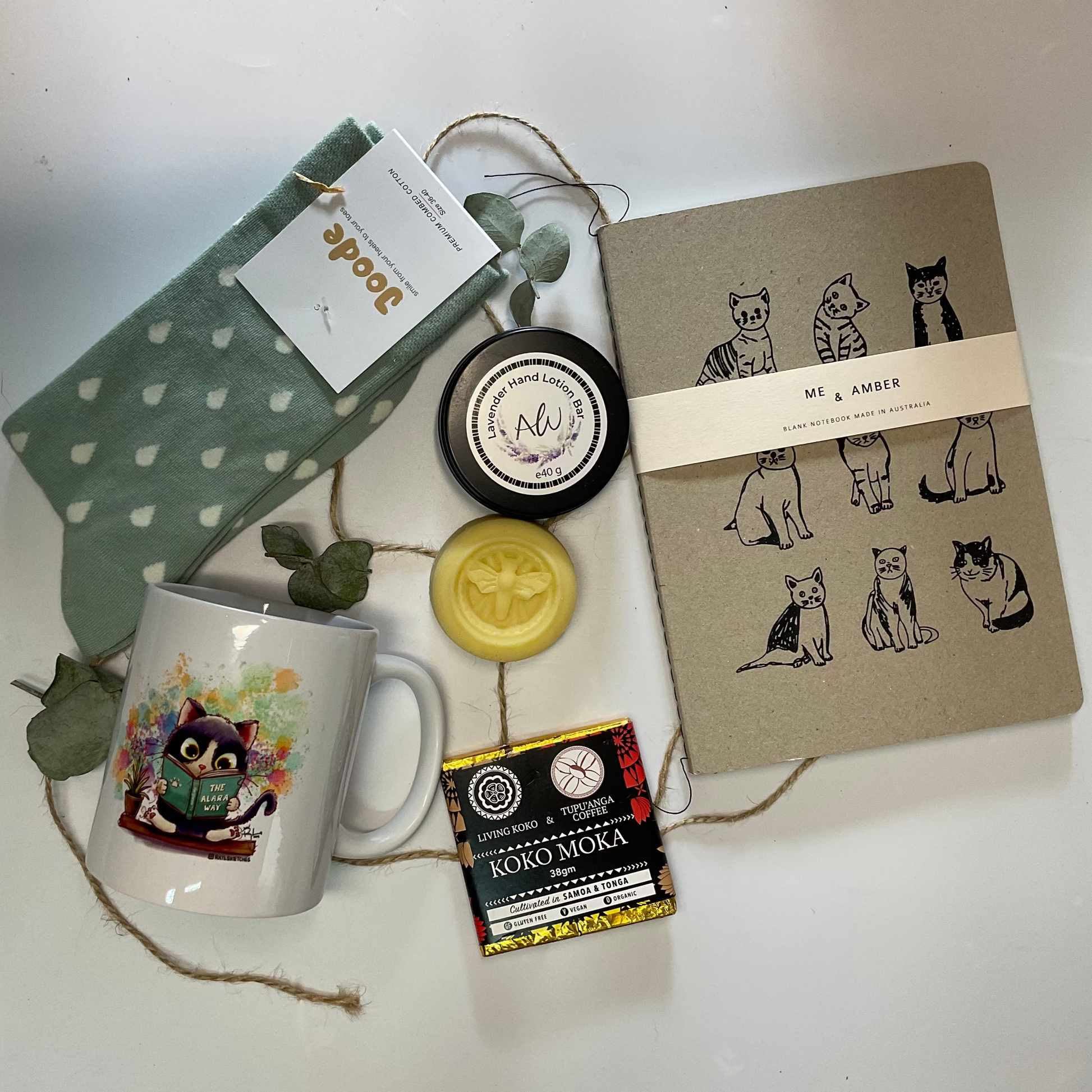 Collection of items including a mug, notebook, and small containers on a white surface.