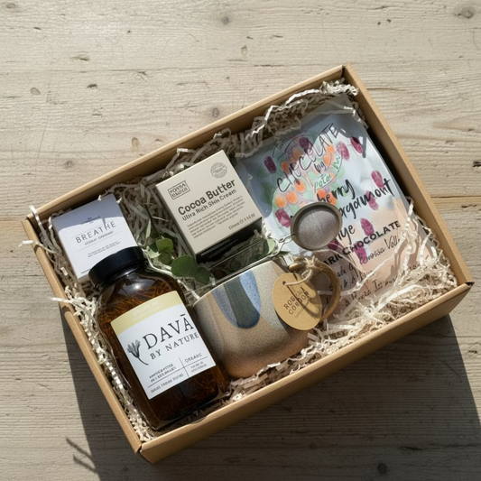 Gifting box with low tox skincare products, a bottle loose tea,mug,tea infuser and a shower steamer in hamper box 