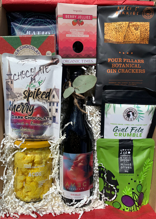 Assorted gourmet food items including crackers, chocolate, and cheese in a box.