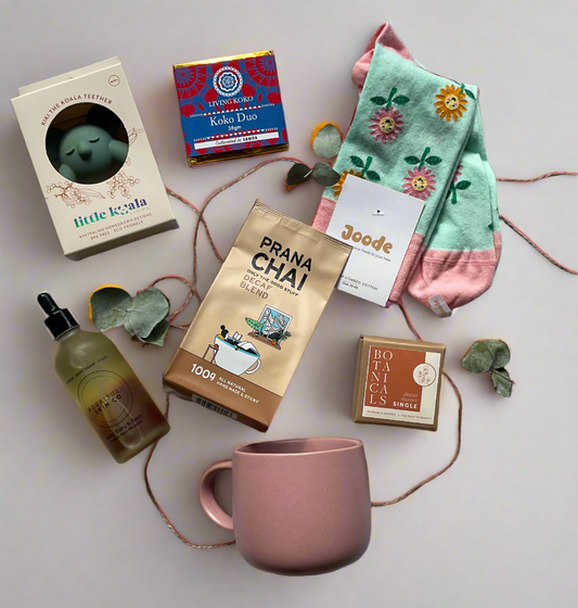 Collection of tea bags, a mug, and decorative items on a light surface