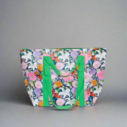 Floral tote bag with green handles on a light gray background