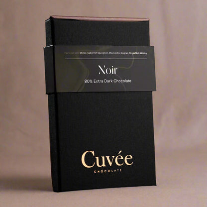 Black chocolate packaging with 'Cuveé' branding on a black background