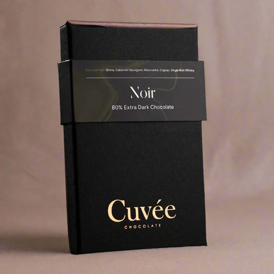 Black chocolate packaging with 'Cuveé' branding on a black background