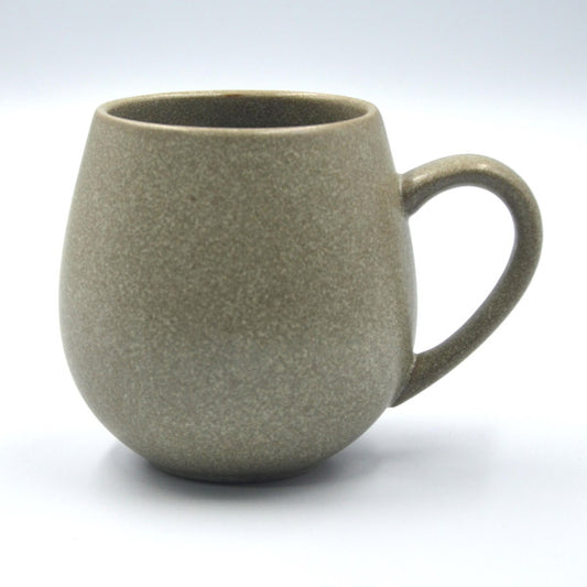 A beige stoneware mug with a handle, microwave and dishwasher safe, with a gloss reactive glaze.