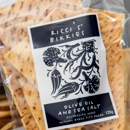 Packaged pita bread with a label reading 'Ricci's Bikkies Olive Oil and Sea Salt' on a clear background.