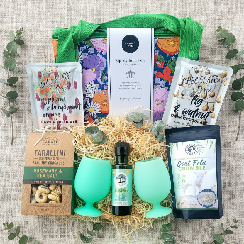 Gift basket with green silicone glasses, chocolate, feta and savoury biscuits.