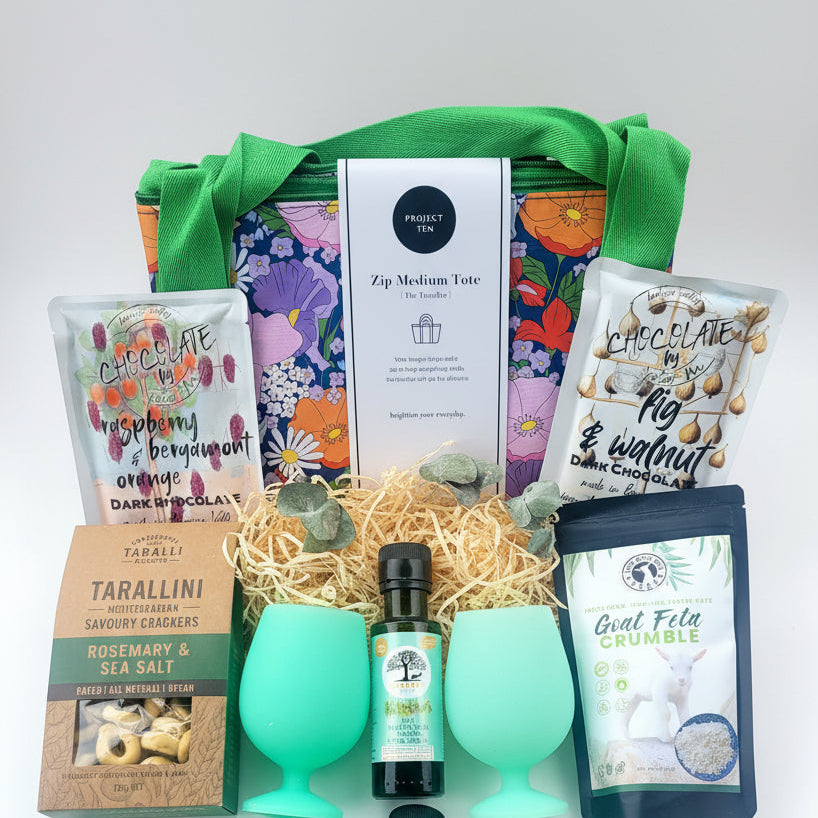Gift basket with green silicone glasses, chocolate, feta and savoury biscuits.