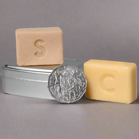 Two square bars of soap with 'S' and 'C' on a white background