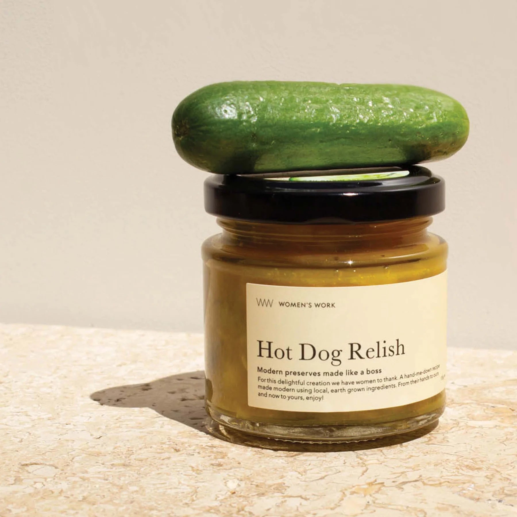 Jar of Hot Dog Relish with a green lid on a beige background