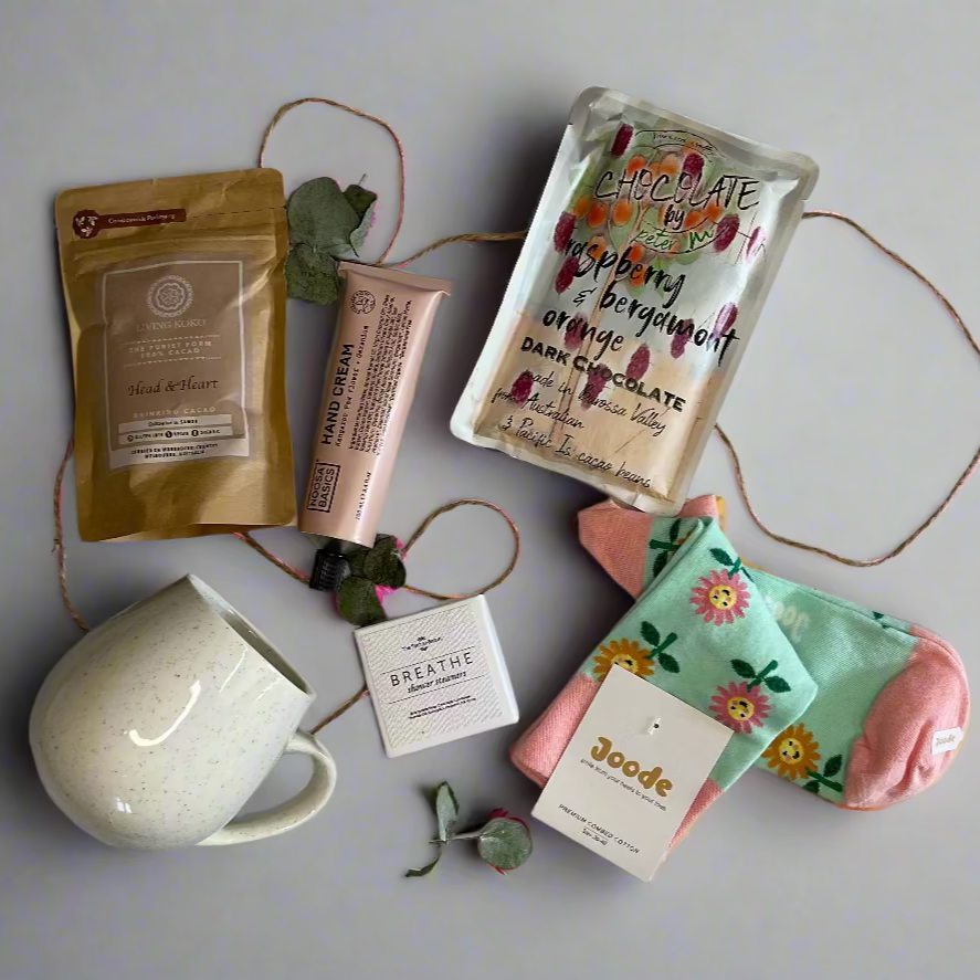 Collection of beauty products including a mug, soap, and skincare items on a white surface.