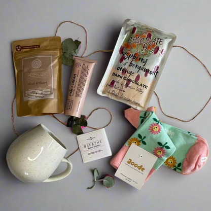 Collection of beauty products including a mug, soap, and skincare items on a white surface.