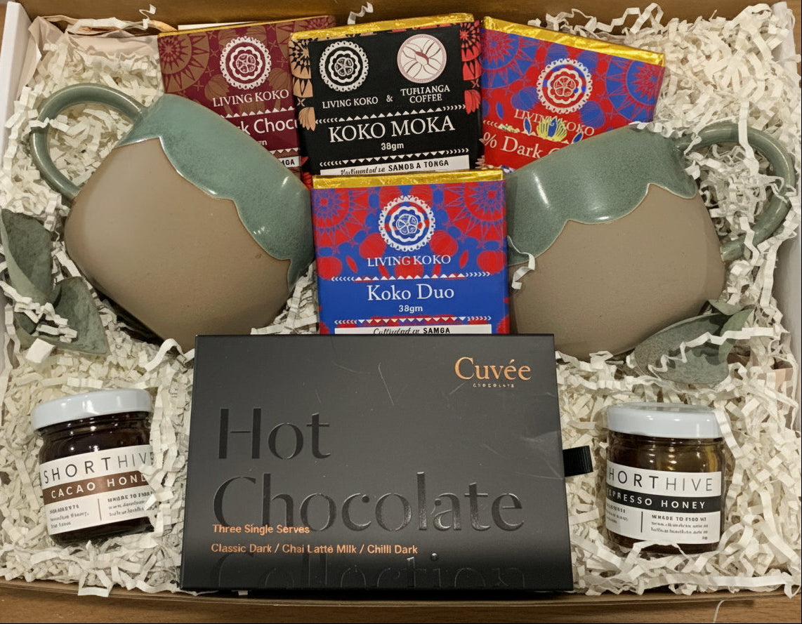 Gift set with hot chocolate mix, cocoa bars, and mugs in a box.