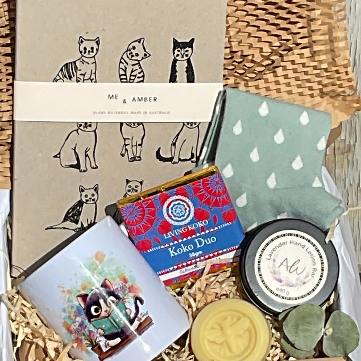 Collection of items including a woven basket, books, and decorative objects on a wooden surface.