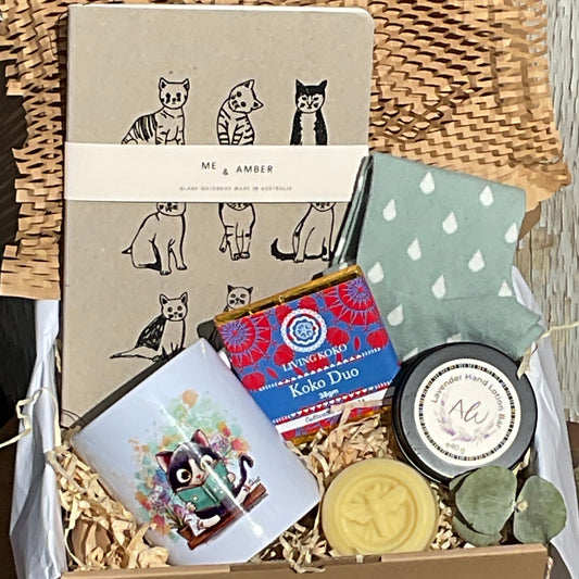 Collection of items including a woven basket, books, and decorative objects on a wooden surface.