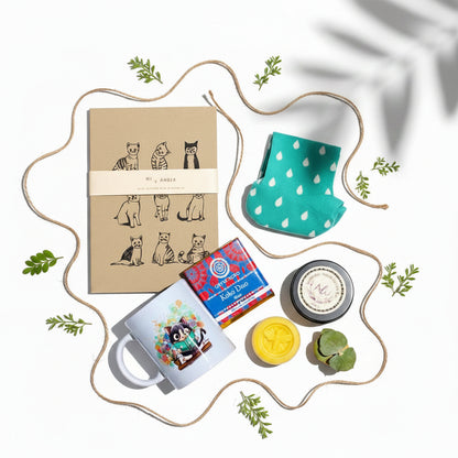 Gift set with stationery items and a cat-themed notebook on a white background