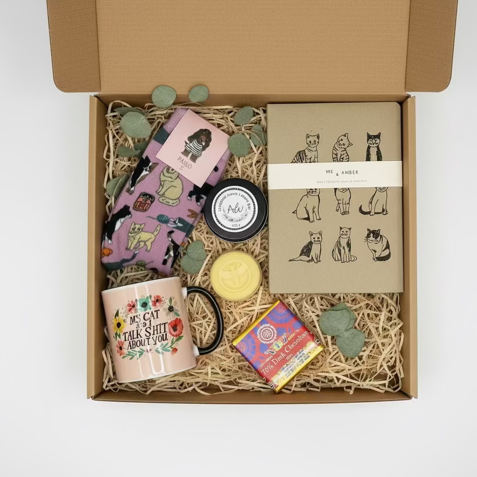 Collection of items including a mug, candles, and packaging on a light surface.