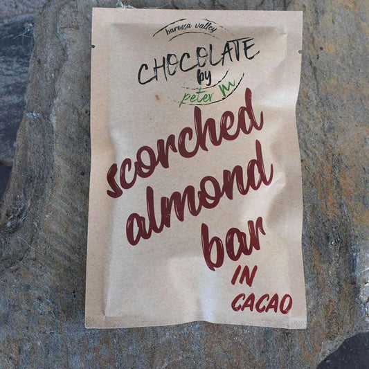 Scorched Almond Bar chocolate packaging on a stone surface