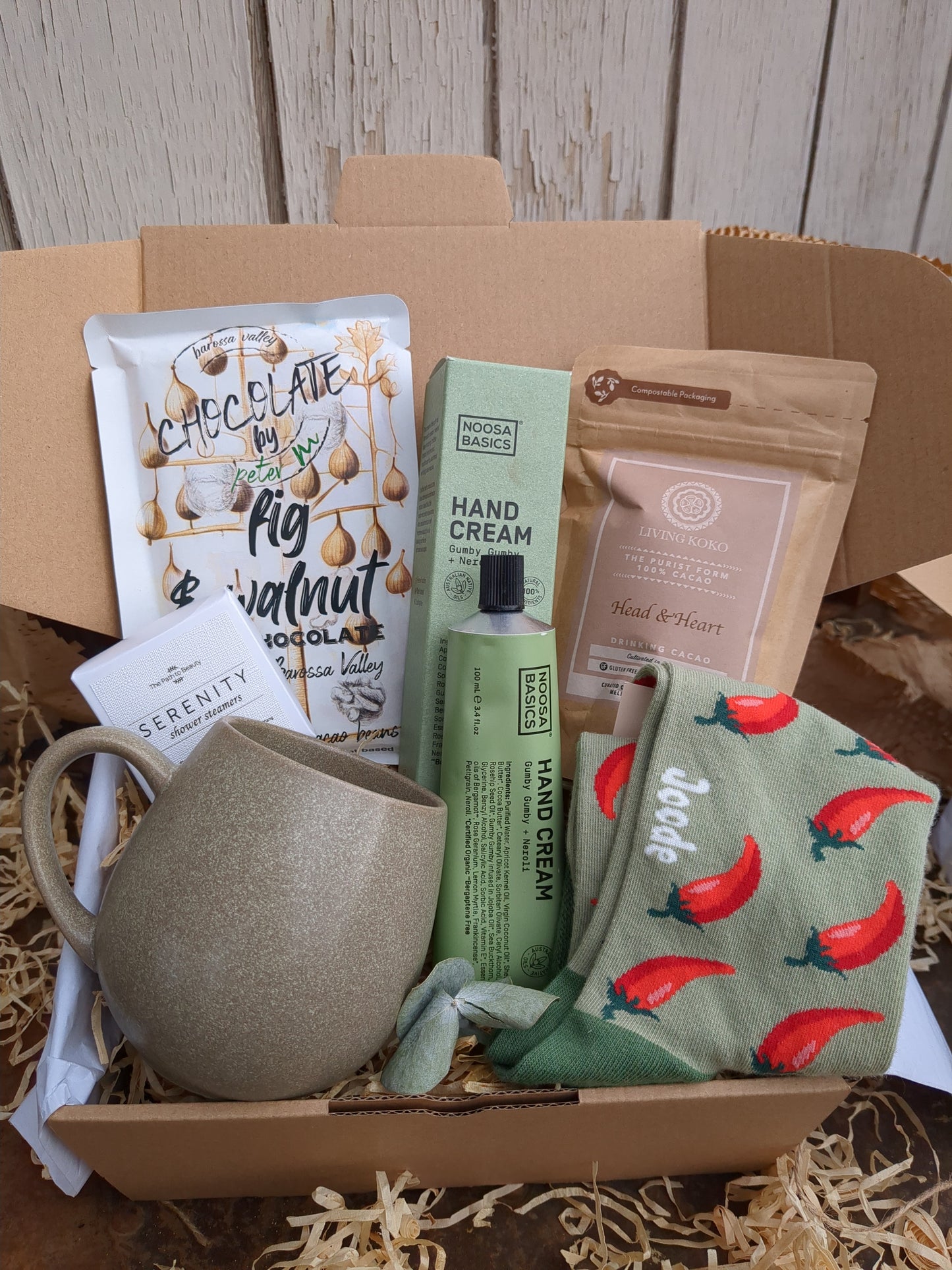 Box containing various items including a mug, hand cream, and a bag of coffee beans.