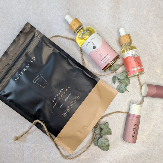 Skincare products including bottles and a bag on a textured surface