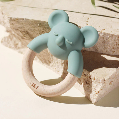 A blue silicone teether in the shape of a koala bear, with a beechwood ring attached to it.
